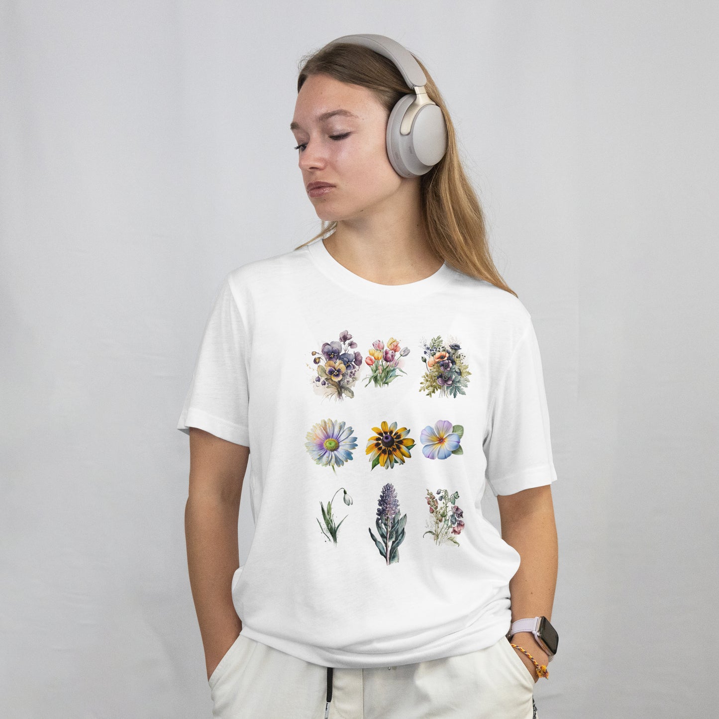 Person wearing a white t-shirt with Set of colorful floral tattoos on a white background and headphones on a plain background