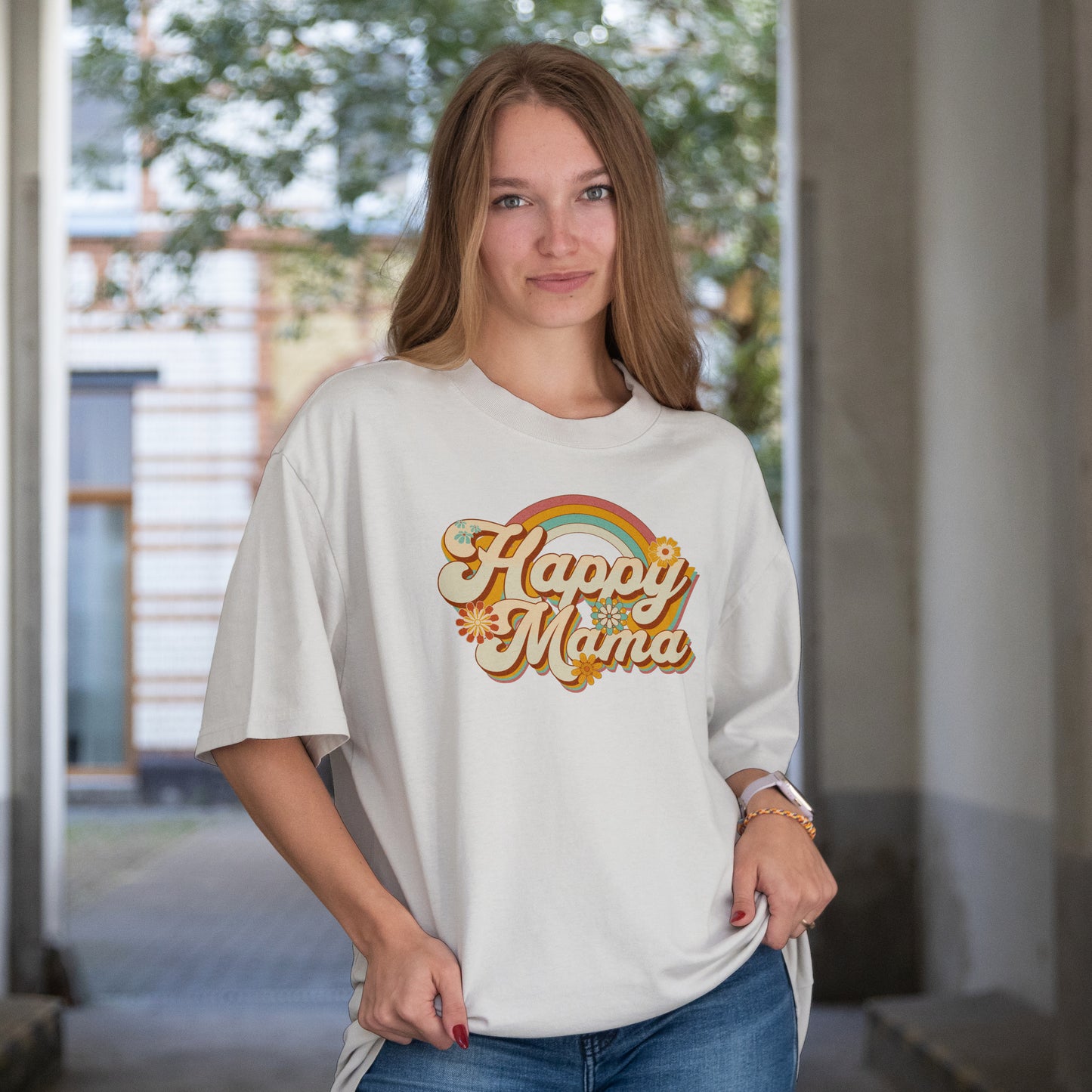 Woman wearing a white t-shirt with 'Happy Mama' text and rainbow design.