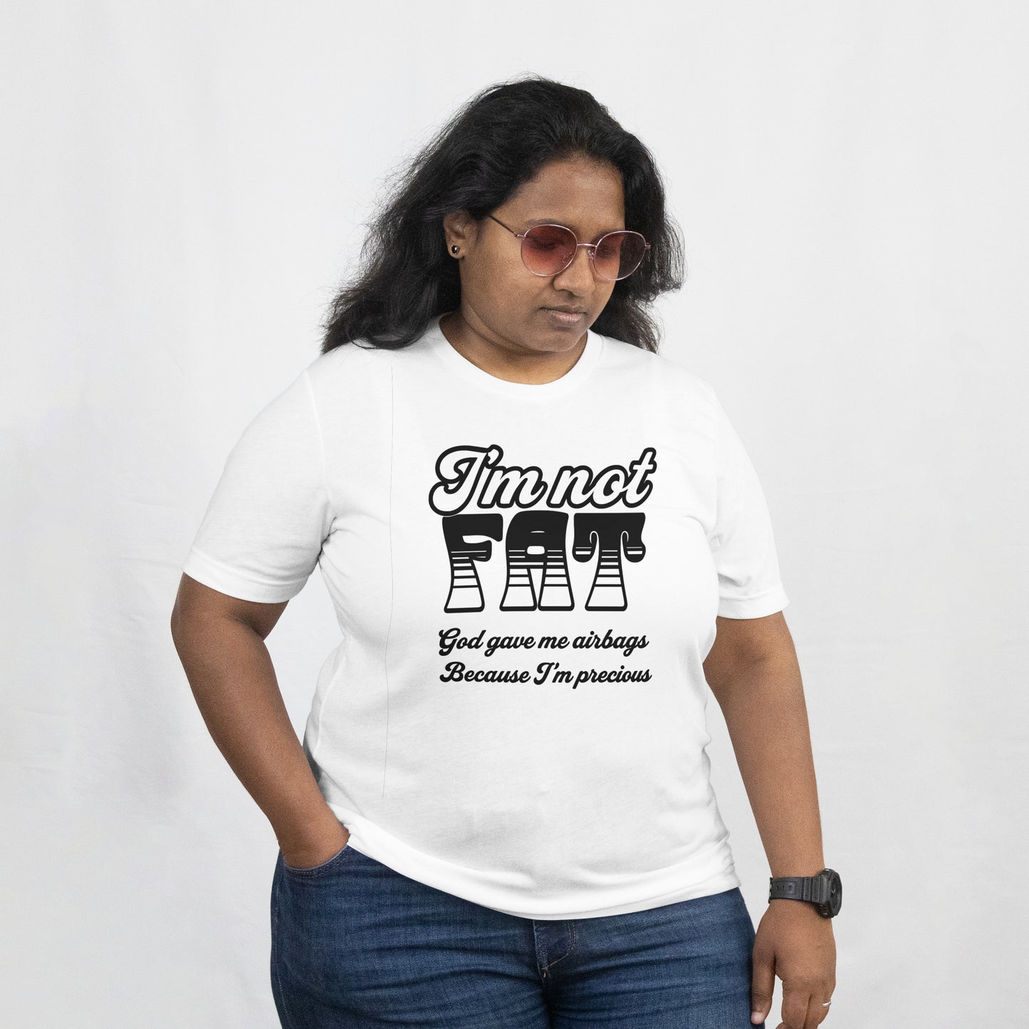 A woman wearing a white T shirt, On the front of the t shirt is written "I'm not Fat God gave me airbags because I'm so Precious."