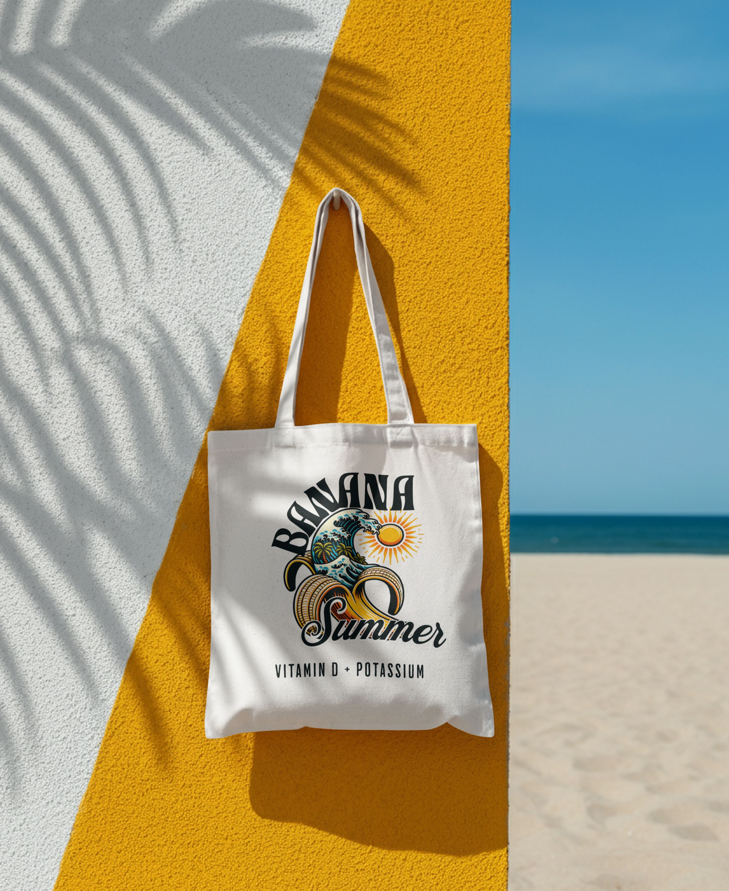 White tote bag with 'Banana Summer' design on a yellow wall with beach background