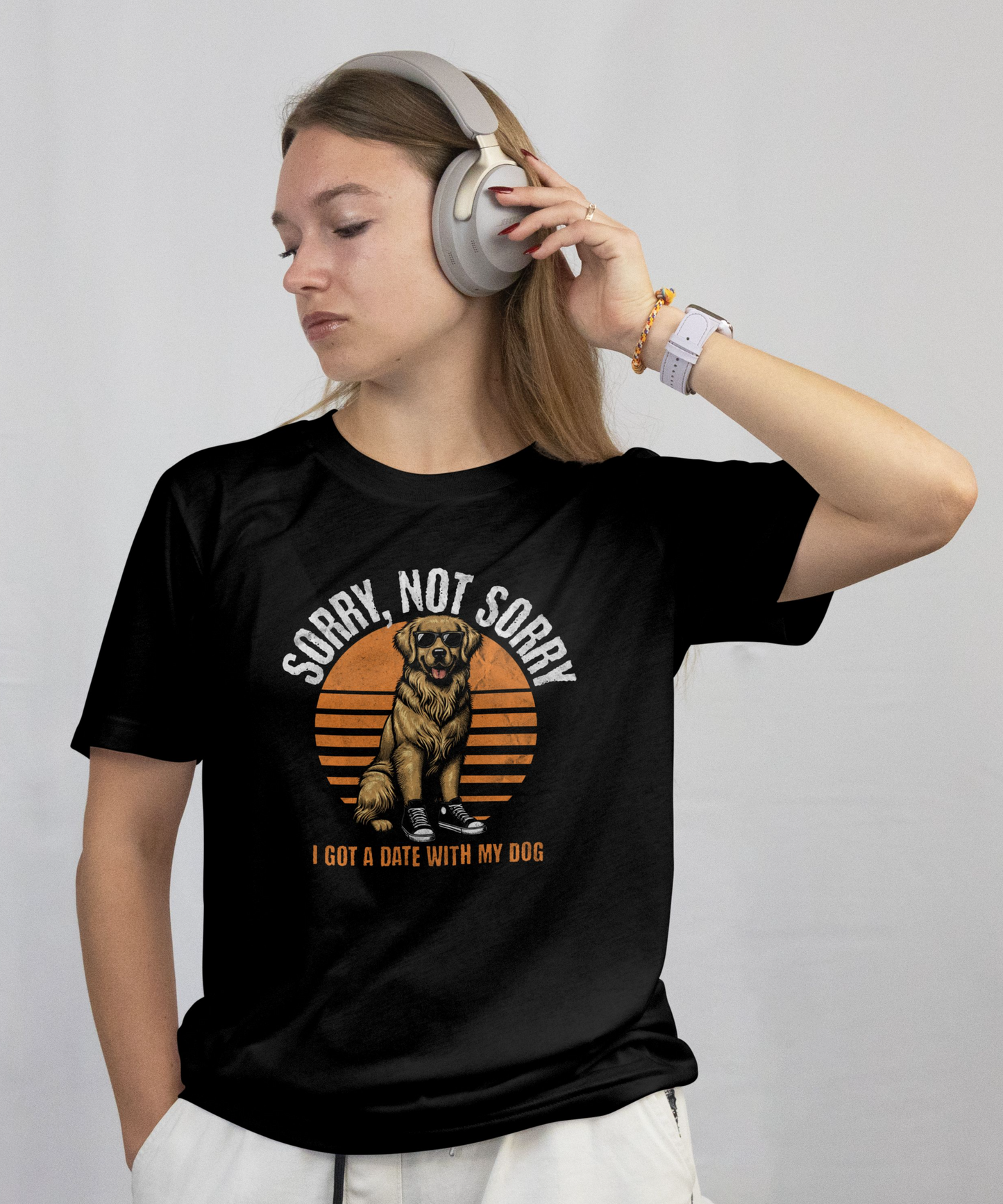 Person wearing a black t-shirt with a graphic design and headphones, on a plain background