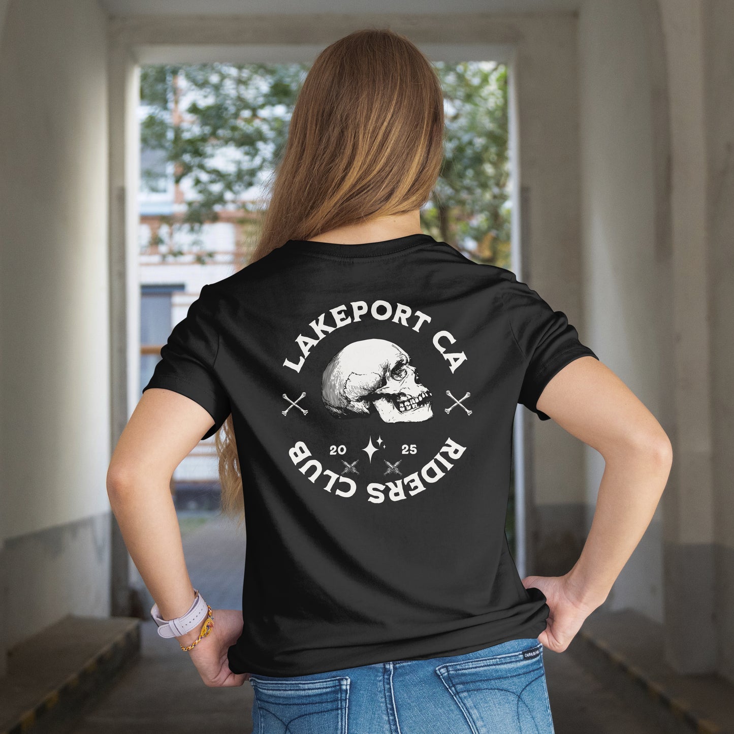 Person wearing a black t-shirt with Logo of Lakeport CA Riders Club with a skull and crossbones design on a black design on the back.