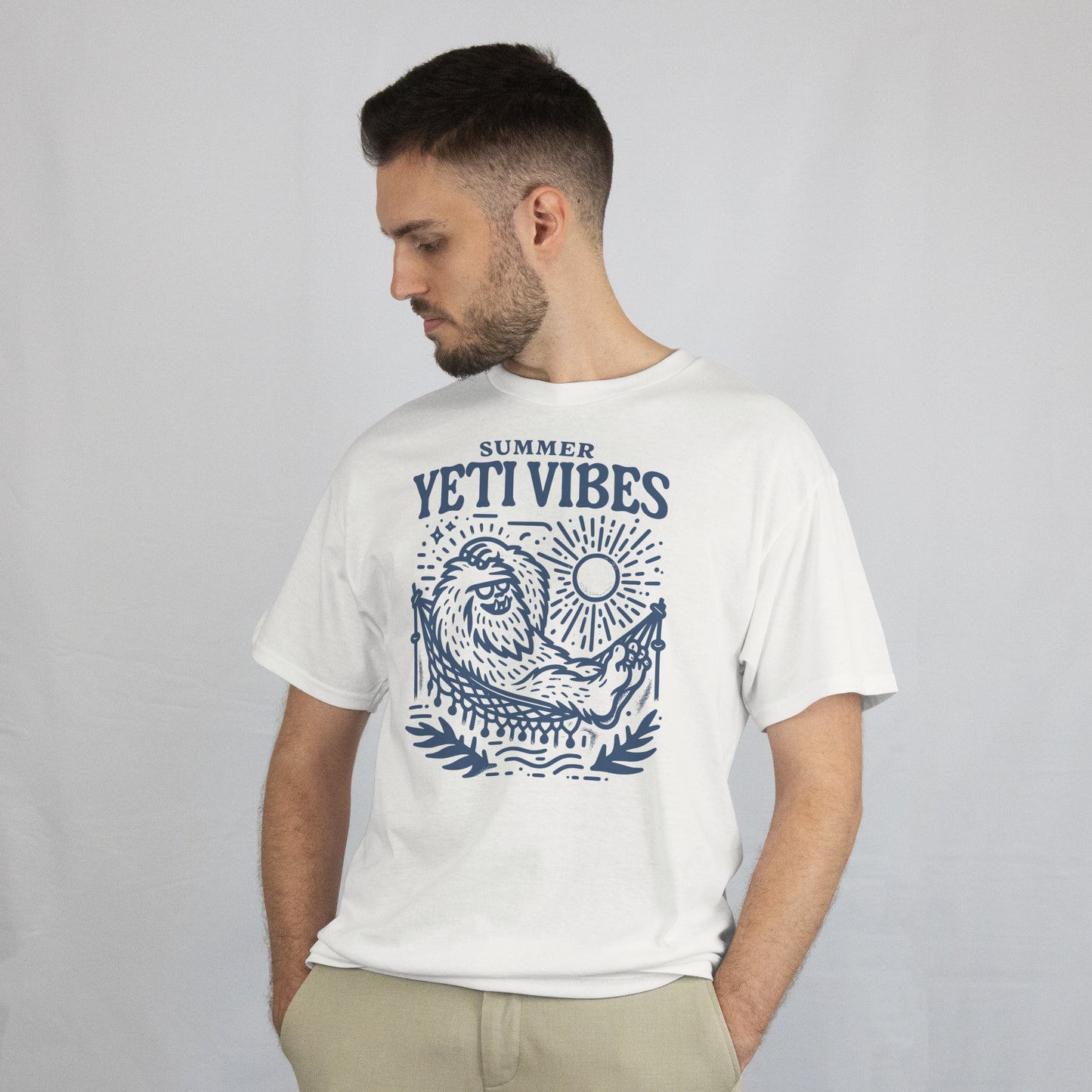 Man wearing a white t-shirt with 'Summer YETI VIBES' graphic design on a plain background