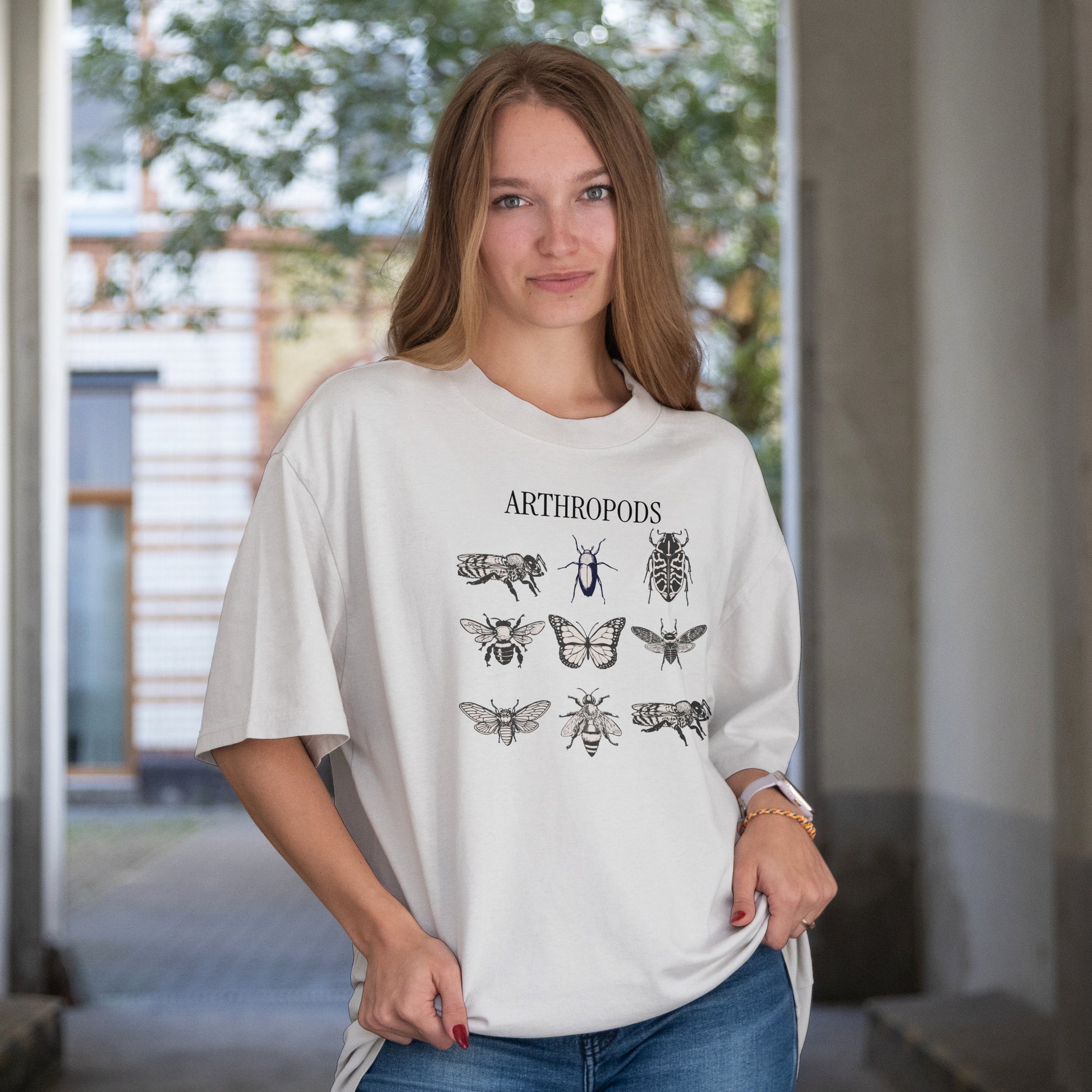 Woman wearing a white t-shirt with Illustrations of various arthropods with the word 'ARTHROPODS' at the top.'.
