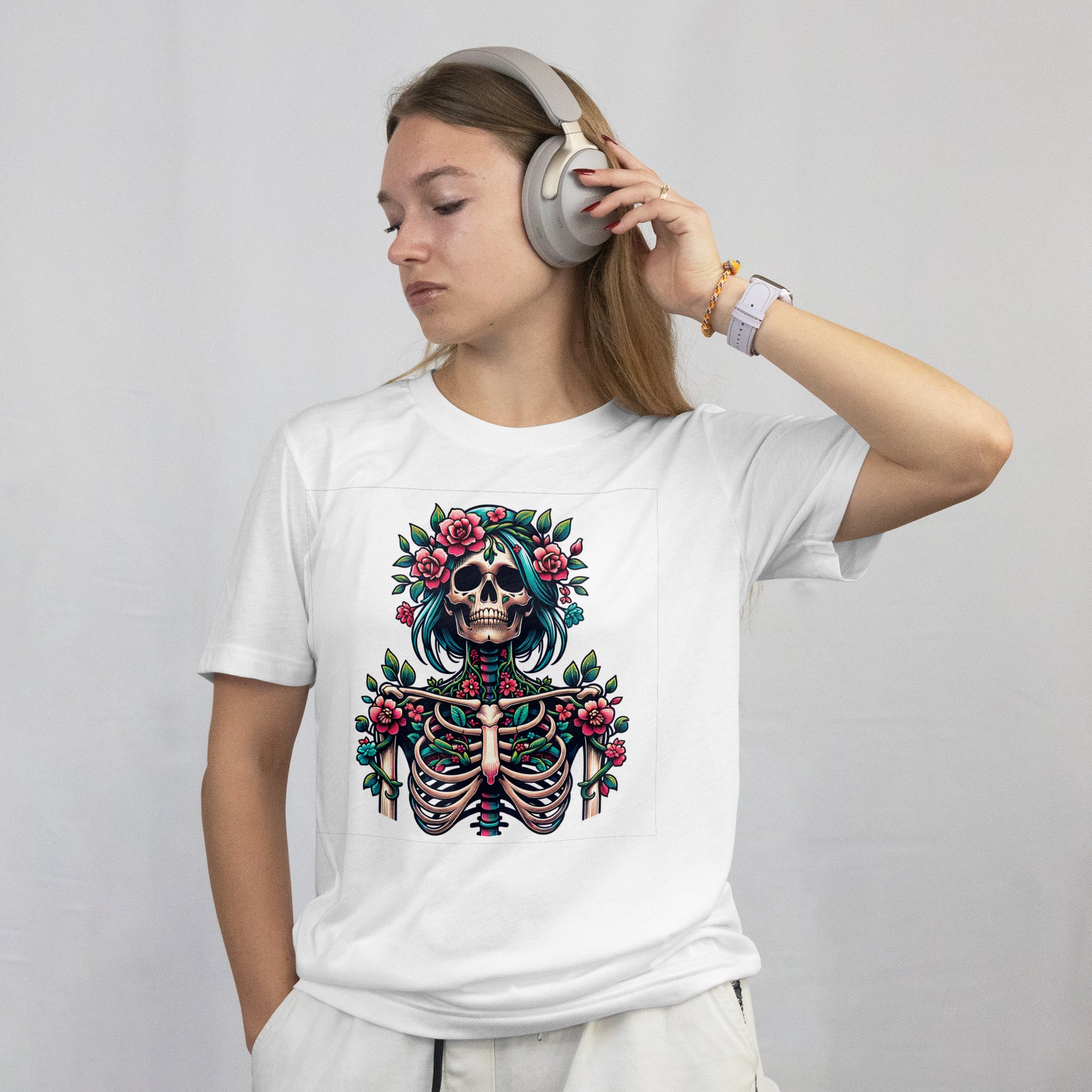 Person wearing a white t-shirt with a skeletal design with teal hair, flowers, and green leaves on a white background, listening to music with headphones.