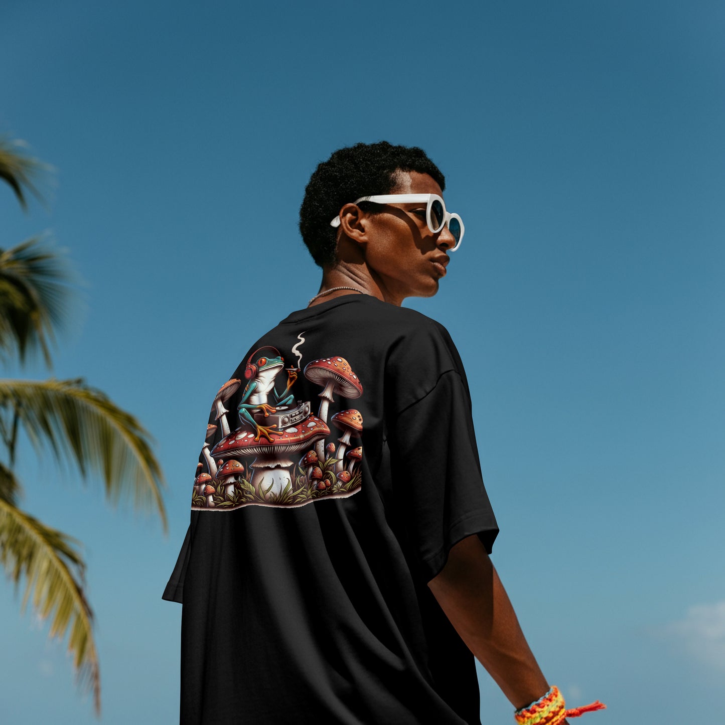 Person wearing a black t-shirt with a frog with headphones smoking a cigarette on a mushroom, surrounded by more mushrooms on the back, standing against a clear blue sky.
