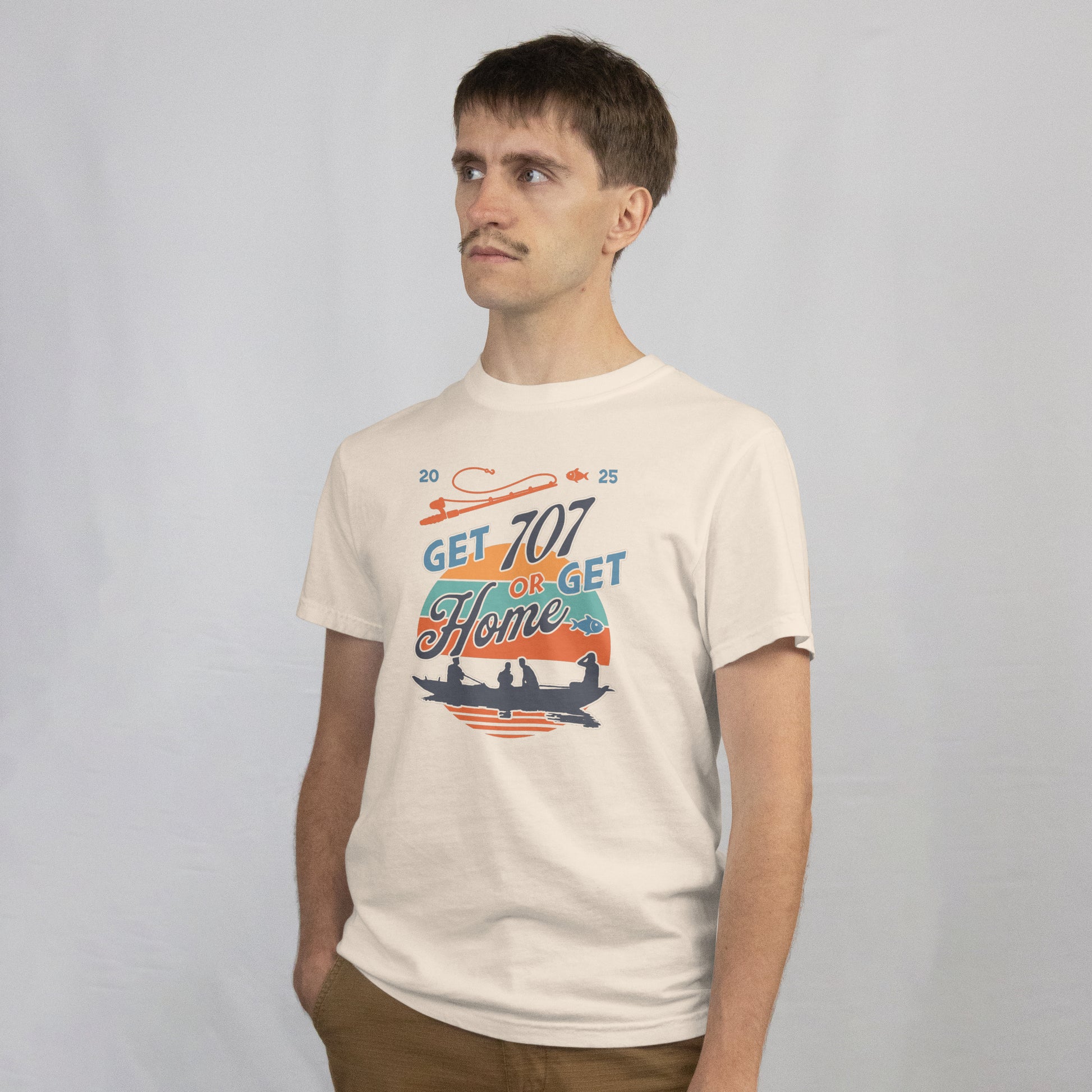 Man wearing a white t-shirt with a Motivational graphic with 'Get 707 or Get Home' text and silhouette of people in a boat.