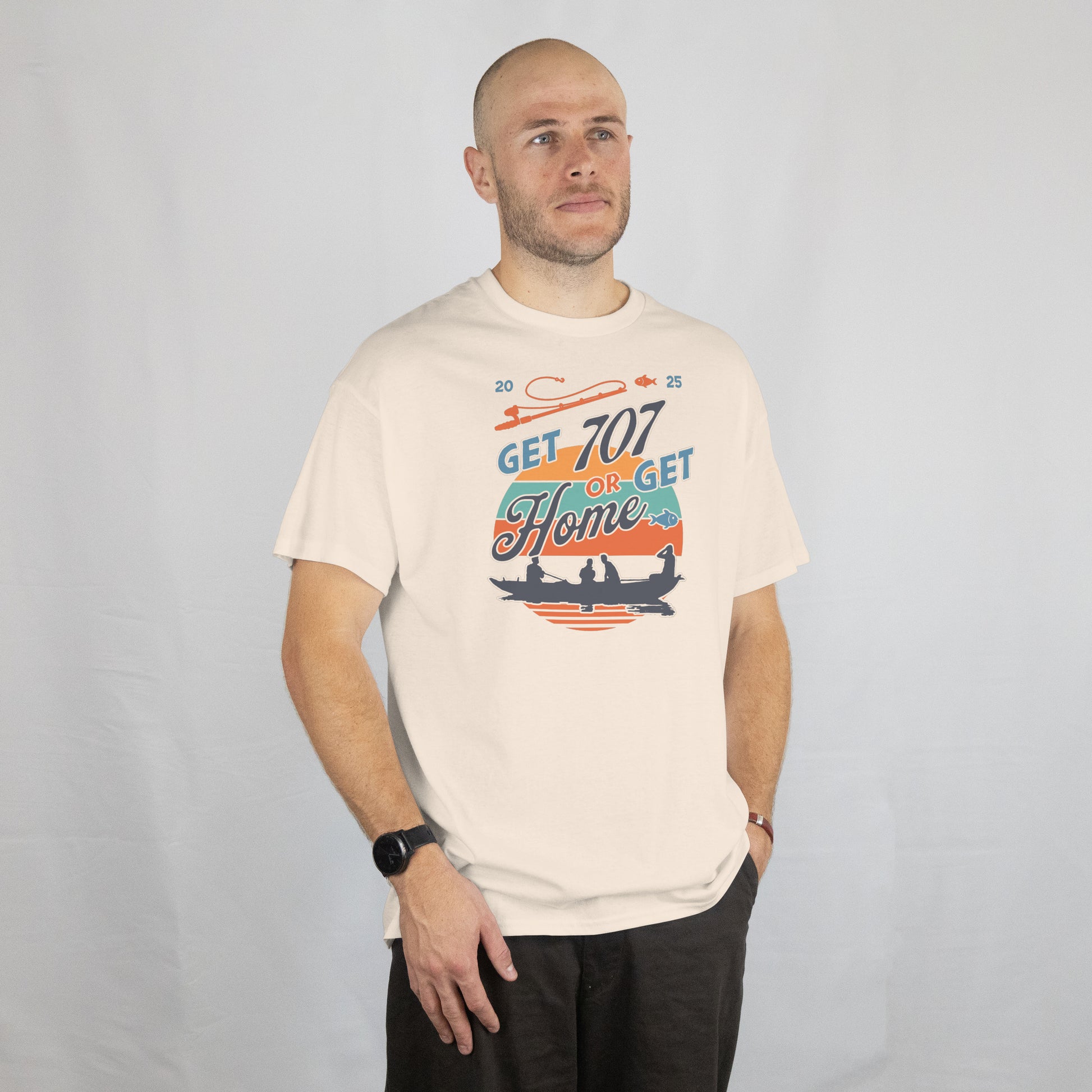 Man wearing a white t-shirt with Motivational graphic with 'Get 707 or Get Home' text and silhouette of people in a boat.