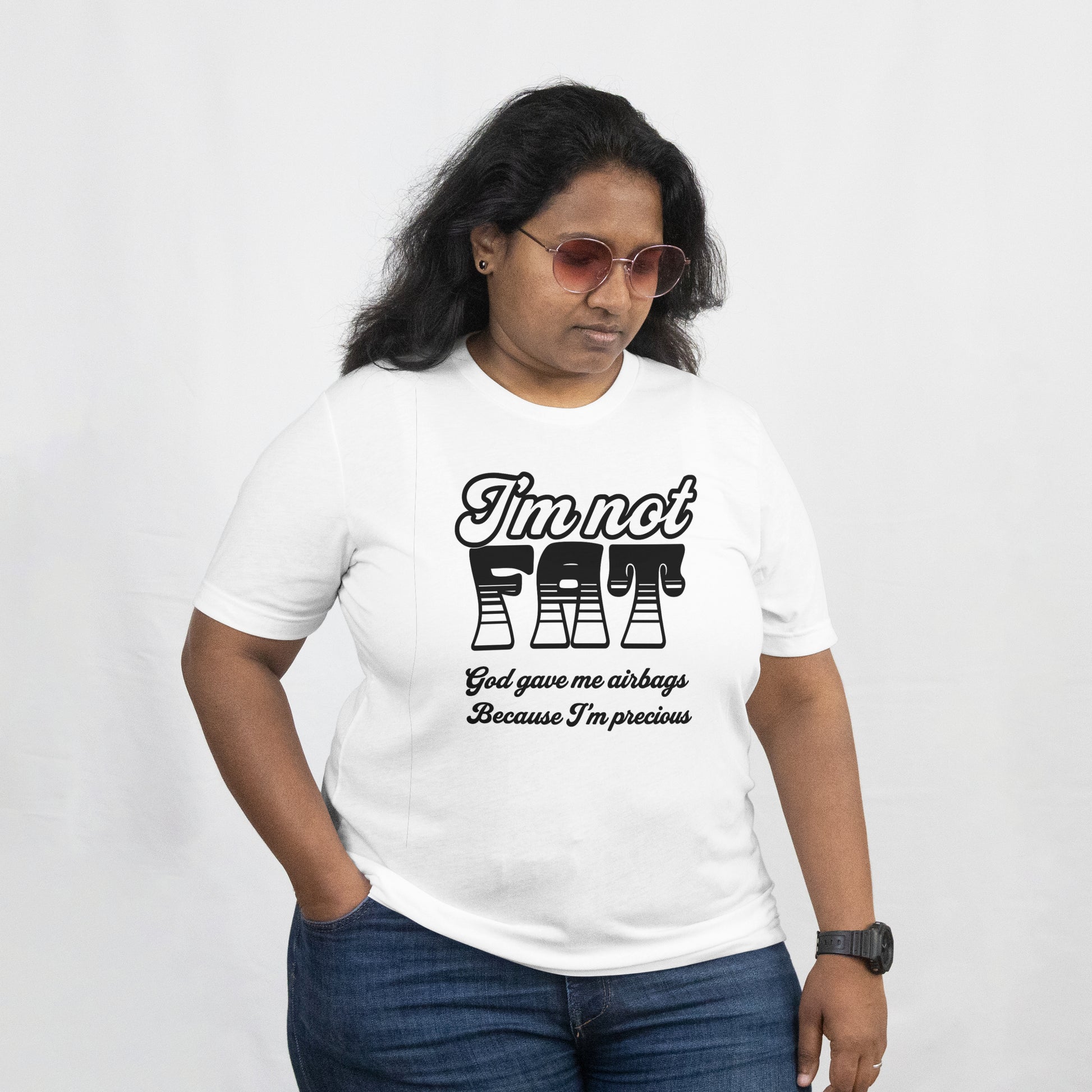 A woman wearing a white T shirt, On the front of the t shirt is written "I'm not Fat God gave me airbags because I'm so Precious." 
