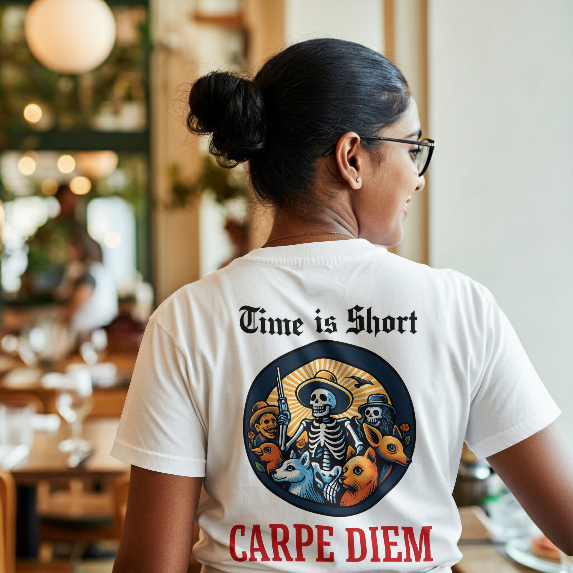 Person wearing a white t-shirt with a Circular design with skeletons, animals, and text 'Time is Short Carpe Diem' on a white background in a casual setting.